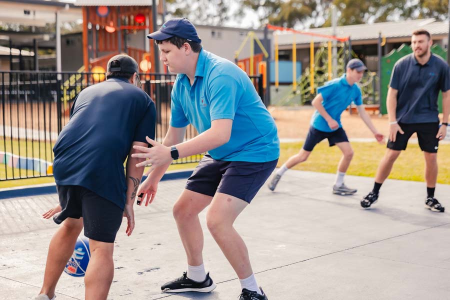 Students and staff taking part in a spirited game of basketball.