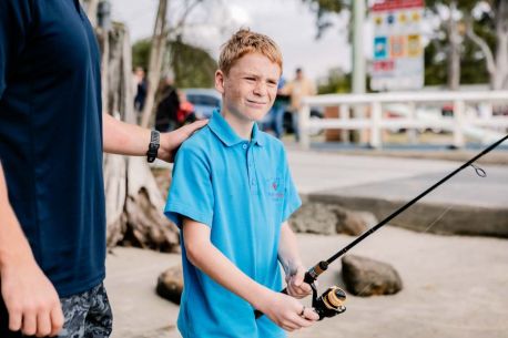 A student enjoying fishing, connecting with the outdoors.