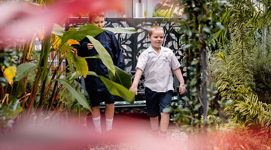 Students walking through the sensory garden, engaging with various textures, scents, and natural elements.