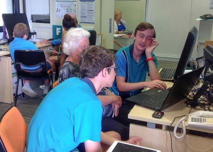 Students assist senior citizens in learning to use an iPad as part of community outreach.