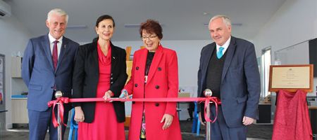 A ceremonial ribbon cutting event celebrating the inauguration of a new school building, a significant milestone for the school community.