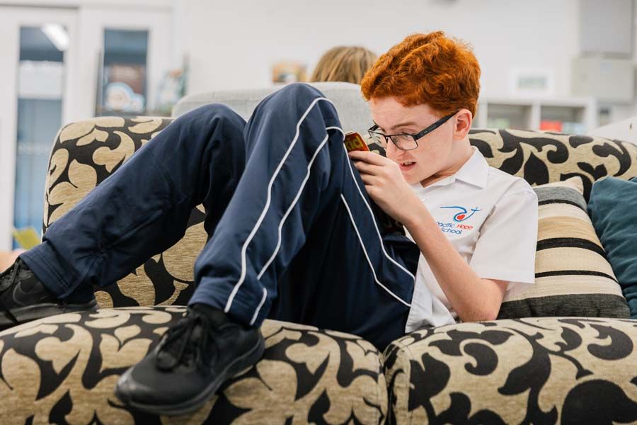 A student finding solace and enjoyment while reading quietly in the school library