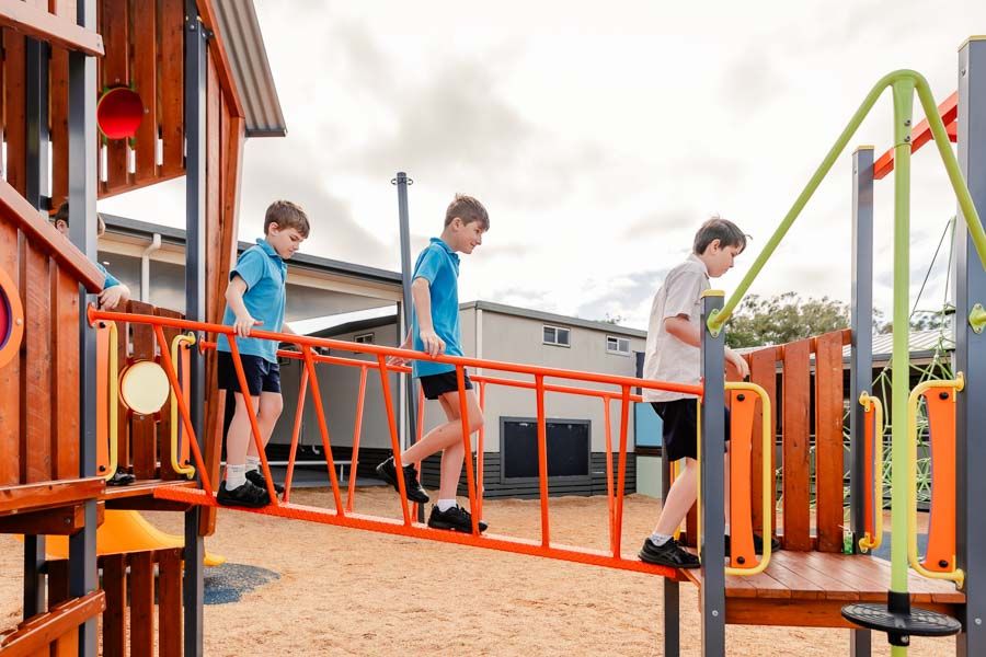 Students exploring and enjoying outdoor play equipment, embracing physical activity and social interaction in the open air.